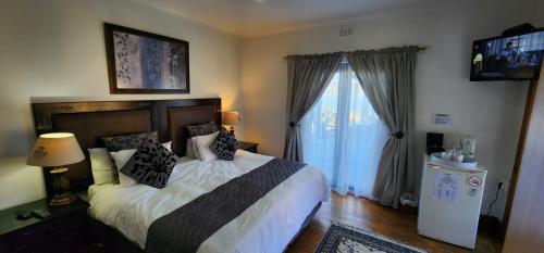 a bedroom with a bed and a large window at Lagoon Lodge in Knysna