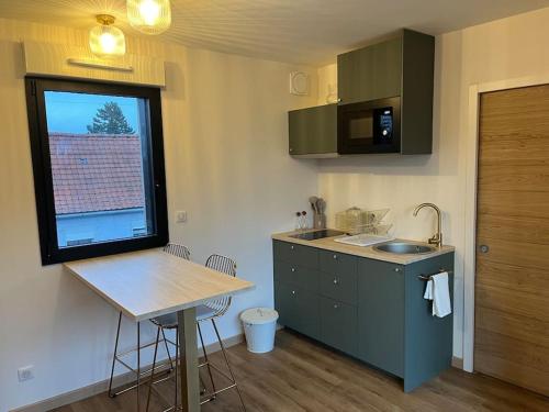 une cuisine avec un comptoir, une table et une fenêtre dans l'établissement Studio à Raimbeaucourt, à Raimbeaucourt