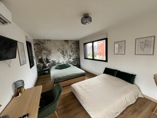 - une chambre avec 2 lits, un bureau et une table dans l'établissement Studio à Raimbeaucourt, à Raimbeaucourt