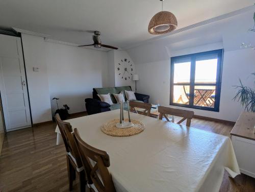 a dining room and living room with a table and chairs at Puerta del Noroeste in Benavente