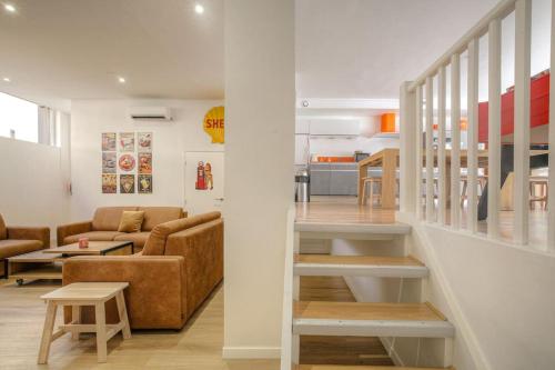 - un salon avec un canapé et un escalier dans l'établissement Happy Days, 150m2 de divertissement, Lyon 7, à Lyon