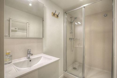 une salle de bain blanche avec un lavabo et une douche dans l'établissement Happy Days, 150m2 de divertissement, Lyon 7, à Lyon