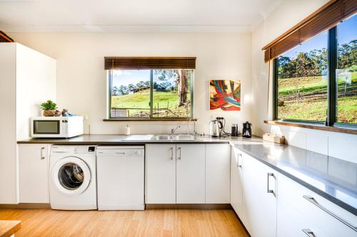 a kitchen with a washing machine and a microwave at Karrak Reach Forest Retreat in Denmark