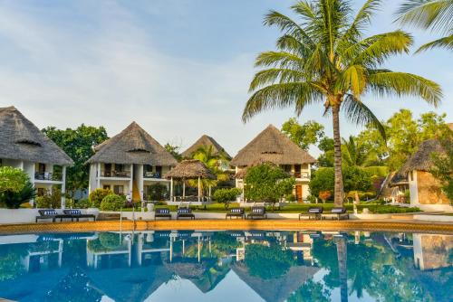 a villa with a palm tree and a swimming pool at Filao Beach by Sansi in Uroa
