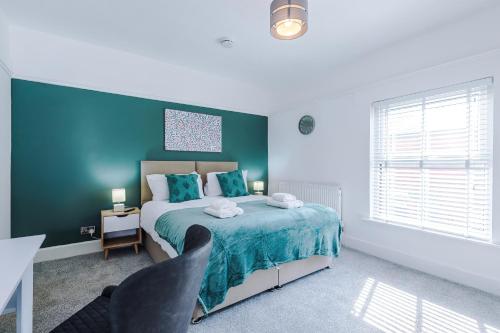 a bedroom with a bed and a blue wall at Serene & Contemporary Hoole House in Chester