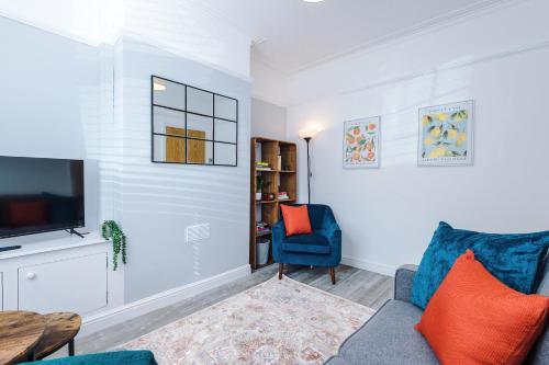 a living room with a blue couch and a tv at Serene & Contemporary Hoole House in Chester