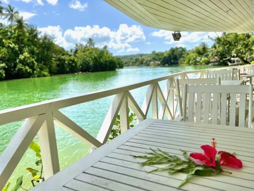 a red flower sitting on a white table next to the water at Tropicana Lagoon Apartments in Port Vila