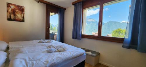 a bedroom with a bed with two flowers on it at SoloHike MountainView in Seelisberg
