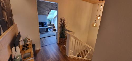 a hallway with a stairway leading to a living room at Almchalet mit Pool und Sauna in Missen-Wilhams