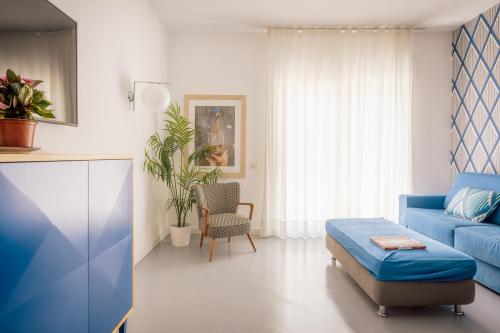 a living room with a blue couch and a table at SorrentoVibes - Luxury Design Home & Jacuzzi in Heart of Sorrento in Sorrento