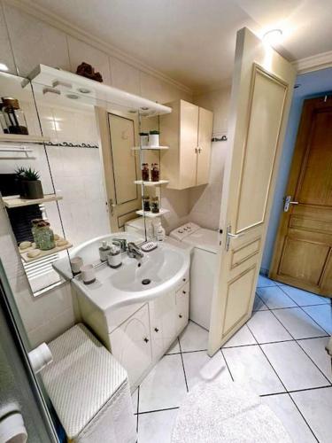 une salle de bain blanche avec un lavabo et une douche dans l'établissement Basilique Métro 13, à Saint-Denis