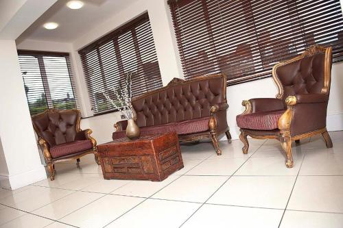 a living room with two chairs and a couch at Grosvenor Hotel Rugby in Rugby