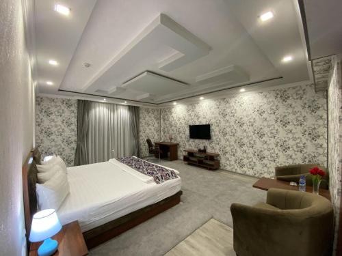 a bedroom with a bed and a couch and a tv at Ахсикент отель in Namangan