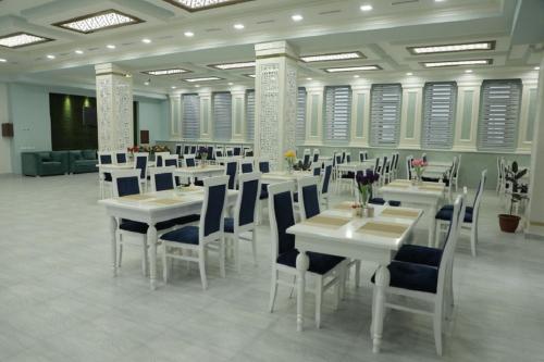 a dining room with white tables and chairs at Ахсикент отель in Namangan