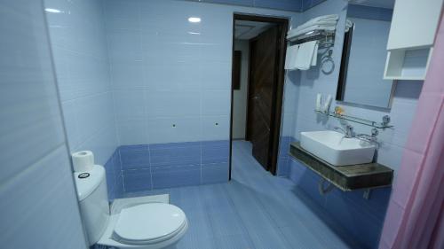 a blue bathroom with a toilet and a sink at Ахсикент отель in Namangan