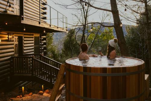 a couple of people sitting in a hot tub at Award-winning A-frame Chalet W Cedar Tub & Views in Julian
