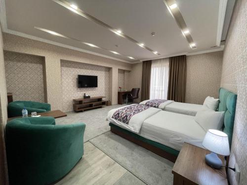 a hotel room with a bed and a tv at Ахсикент отель in Namangan