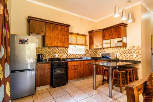 a kitchen with wooden cabinets and a stainless steel refrigerator at ATKV Klein-Kariba in Bela-Bela