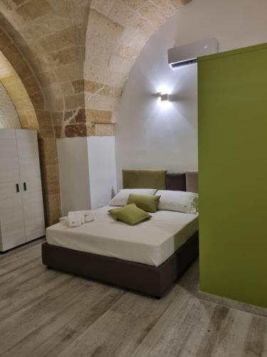 a bedroom with a bed and a green wall at AvVolta nel Salento - Room & Relax in Torchiarolo