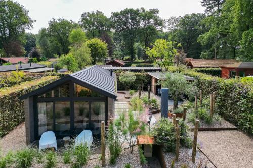 an image of a garden with a greenhouse at Modern ingericht chalet op groen park op de Veluwe in Epe