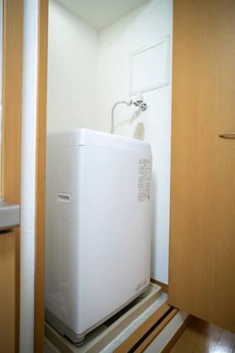 a kitchen with a white refrigerator in a room at 新小岩デメテル303 in Tokyo