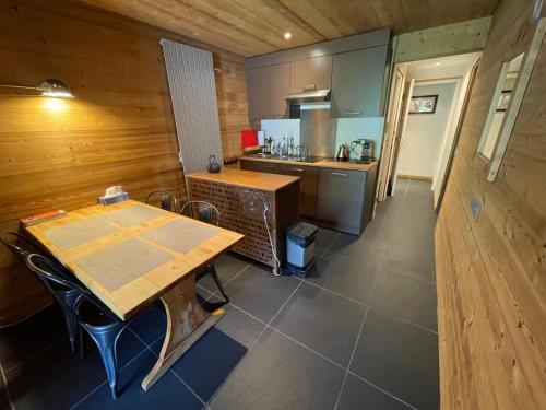 - une cuisine avec une table en bois et un comptoir dans l'établissement Wintergarten, à Valmorel