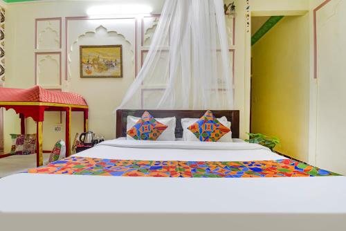 斋浦尔FabHotel Prism Homestay的一间卧室配有一张带彩色床罩的床