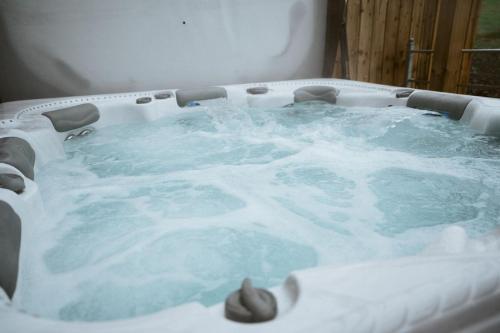a jacuzzi tub covered in snow in a room at The Byre at Conker Tree Cottages in Saintfield