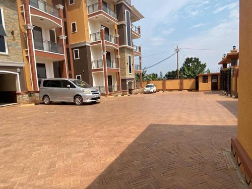 a car parked in a parking lot next to a building at Cozy 1 BR APT in Kampala on Mutungo Hill in Kampala