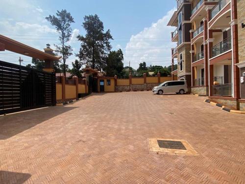 a car parked in a parking lot next to a building at Cozy 1 BR APT in Kampala on Mutungo Hill in Kampala