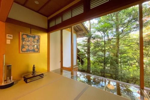 a room with a large window with a view of a forest at Koyasan Sanadabo Rengejoin in Koyasan
