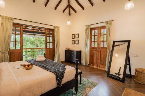 a bedroom with a large bed and a mirror at ELIVAAS 4 BHK with Pvt Pool near Baga - Celest in Old Goa