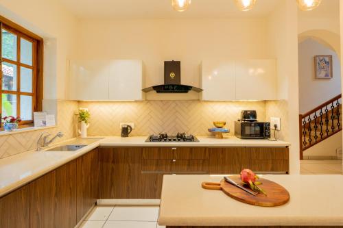 a kitchen with a wooden cutting board on a table at ELIVAAS 4 BHK with Pvt Pool near Baga - Celest in Old Goa