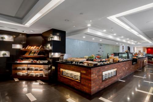 a restaurant with a counter with food on it at Meliá Kuala Lumpur in Kuala Lumpur