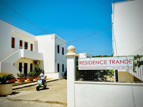 a person riding a scooter in front of a resistance triangle sign at Residence Trande in Leuca