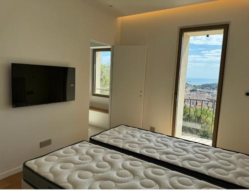 une chambre avec un lit et une grande fenêtre dans l'établissement Luxueuse villa Mougins, à Mougins