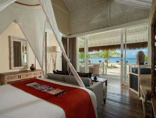 a bedroom with a bed and a view of the ocean at Sudamala Resort, Seraya, Flores in Labuan Bajo