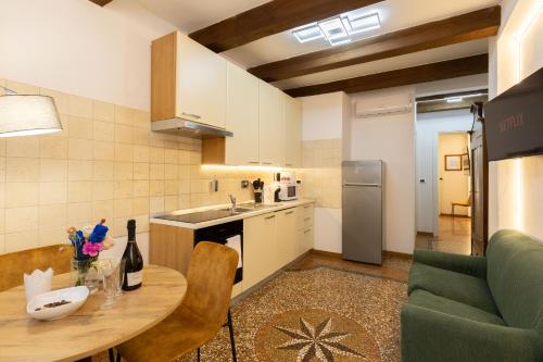 a small kitchen with a table and a couch at BolognaRoomscom - Frassinago Deluxe in Bologna