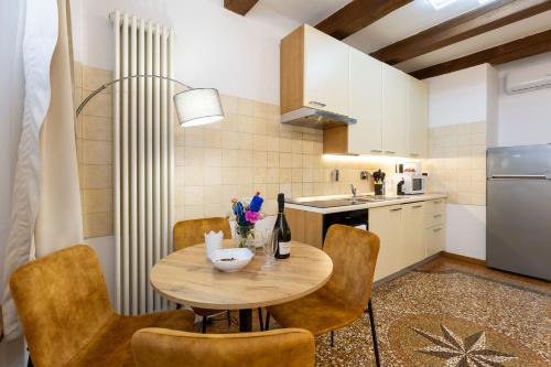 a kitchen with a table and chairs in a kitchen at BolognaRoomscom - Frassinago Deluxe in Bologna