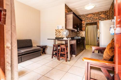 a living room with a table and a kitchen at ATKV Klein-Kariba in Bela-Bela