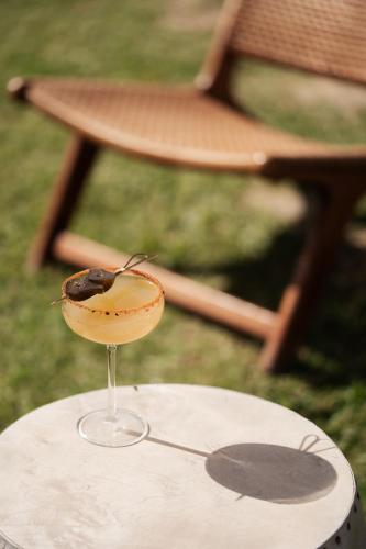 a wine glass sitting on top of a table with a chair at Blue Carpet Luxury Suites in Pefkohori