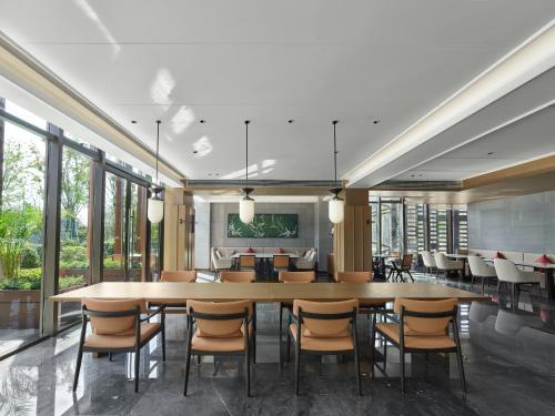 ein großes Esszimmer mit einem großen Tisch und Stühlen in der Unterkunft HOMM Huzhou Xisai Shan in Huzhou