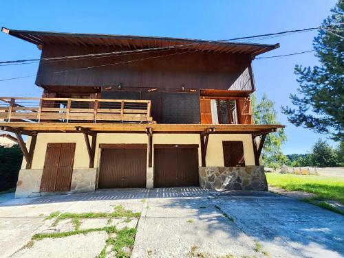 a house with a deck on top of it at Appartement Chalet Cozy au pied des pistes! in Saint-Pierre-dels-Forcats