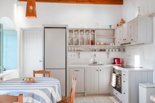 a kitchen with white cabinets and a table with a tablecloth at Demati house in Patmos