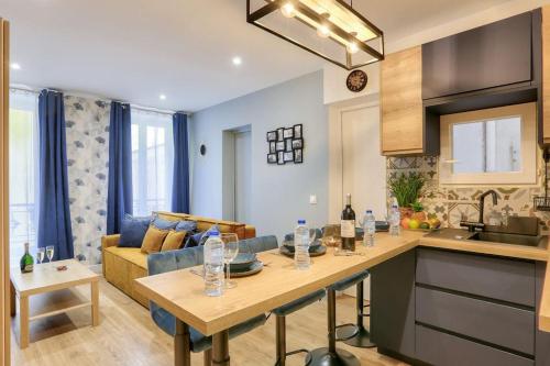 une cuisine et un salon avec un canapé et une table dans l'établissement Bel appartement - 2 chambres au centre de Paris, à Paris