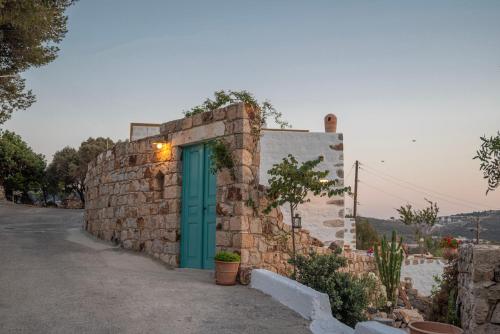 a stone wall with a green door on a building at Demati house in Patmos