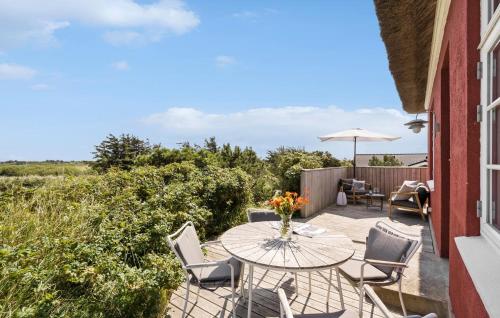 a patio with a table and chairs and an umbrella at Two-Bedroom Holiday Home In Ringkobing in Ringkøbing