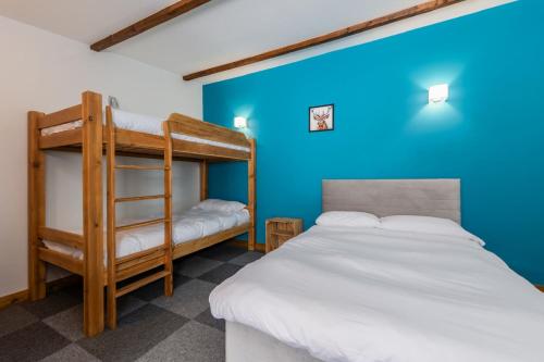 a bedroom with two bunk beds and a blue wall at Cosy Glamping In the Eskdale Valley - Studio Lodges and Mega Pods in Eskdale