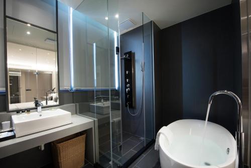 a bathroom with a sink and a shower and a toilet at Hotel Reve Taichung in Daya