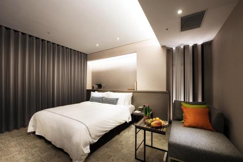 Säng eller sängar i ett rum på Hotel Reve Taichung